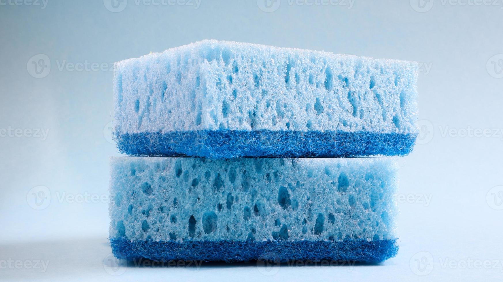 Two blue sponges used for washing and erasing dirt used by housewives in everyday life. They are made of porous material such as foam. Detergent retention, which allows you to spend it economically photo