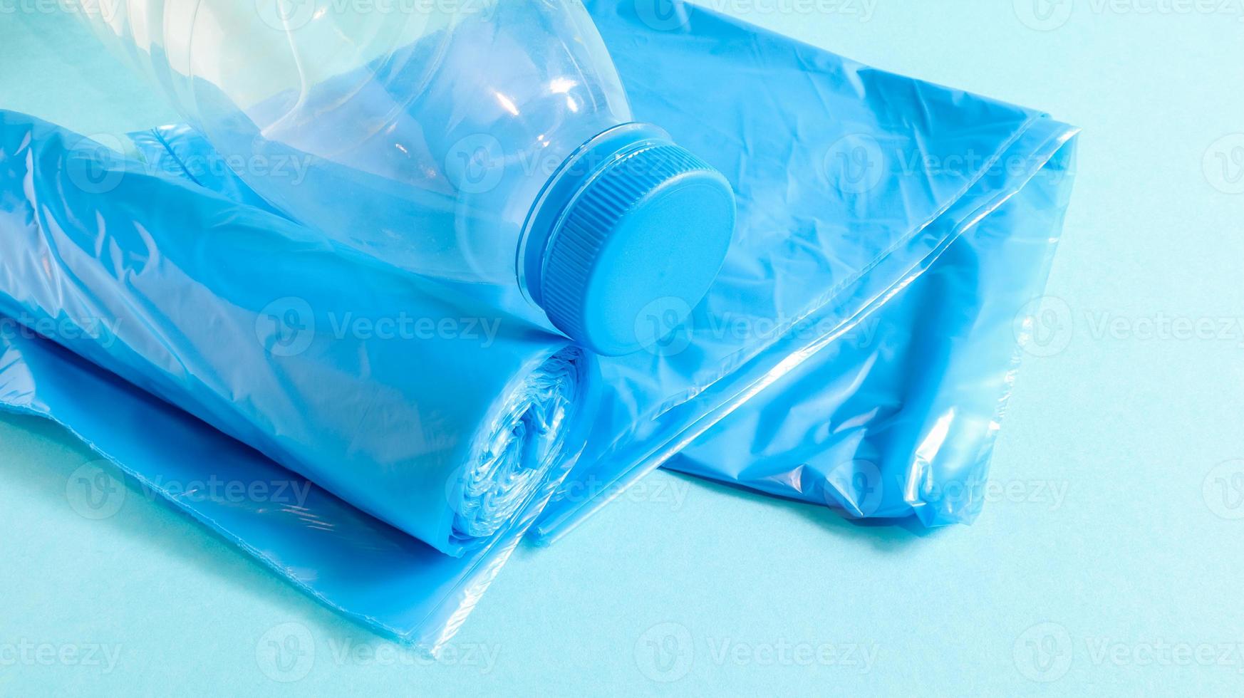 One roll of plastic trash bags in blue on a blue background. Bags that are designed to accommodate garbage in them and used at home and placed in various garbage containers. Copy space photo