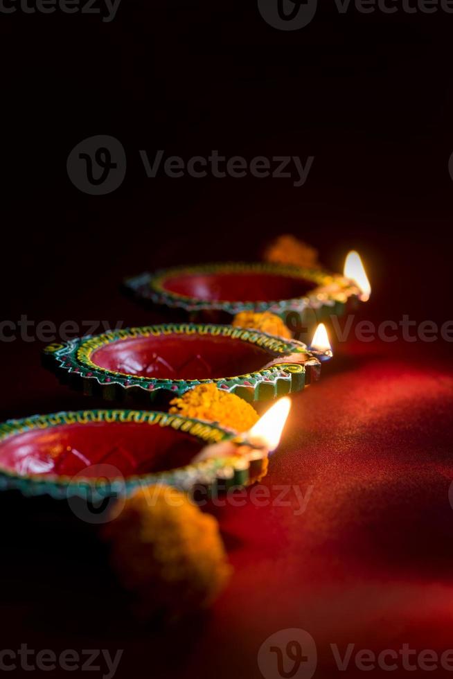 Happy Diwali - Clay Diya lamps lit during Diwali celebration. Greetings Card Design of Indian Hindu Light Festival called Diwali photo