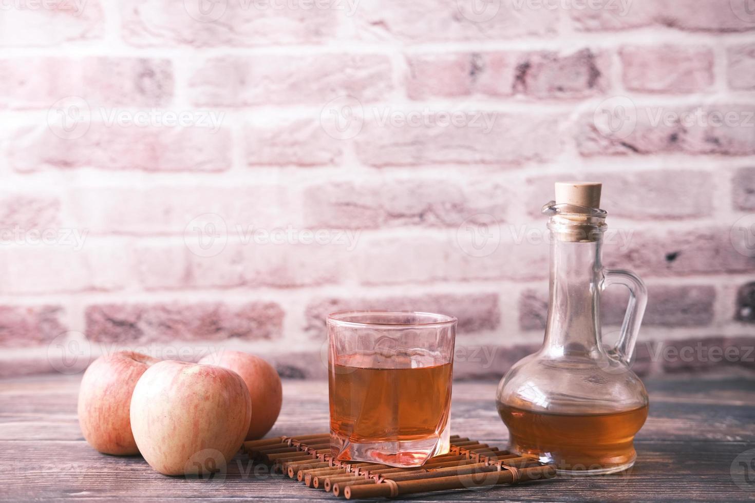 apple vinegar in glass bottle with fresh green apple on table photo