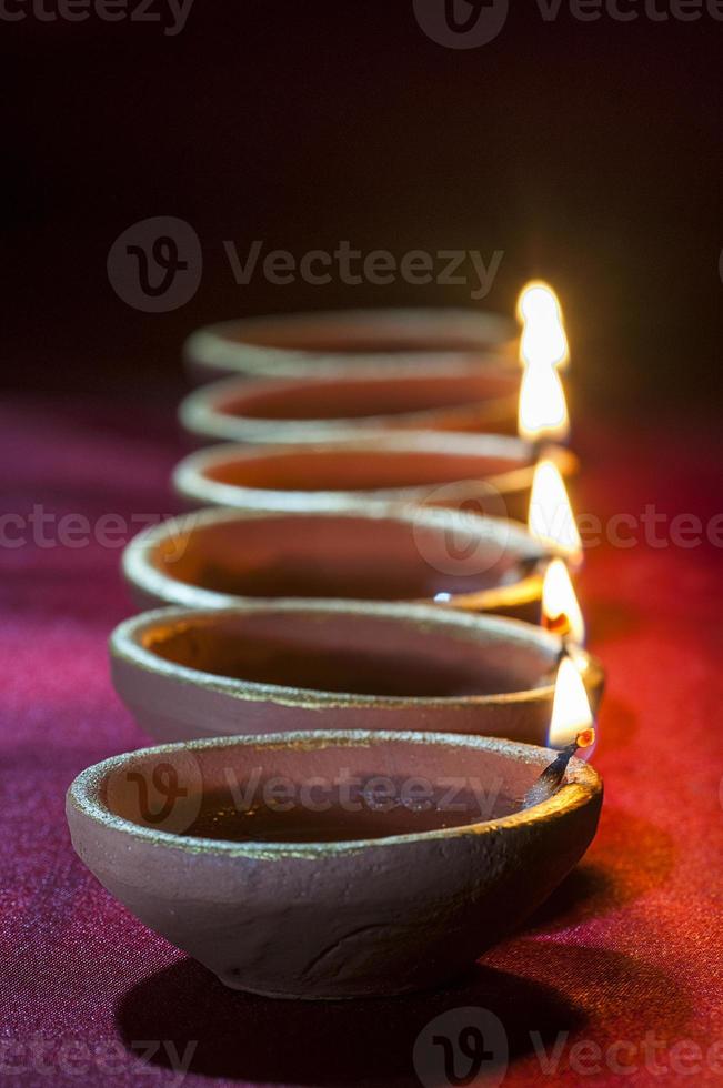 Clay diya lamps lit during Diwali Celebration. Greetings Card Design Indian Hindu Light Festival called Diwali photo