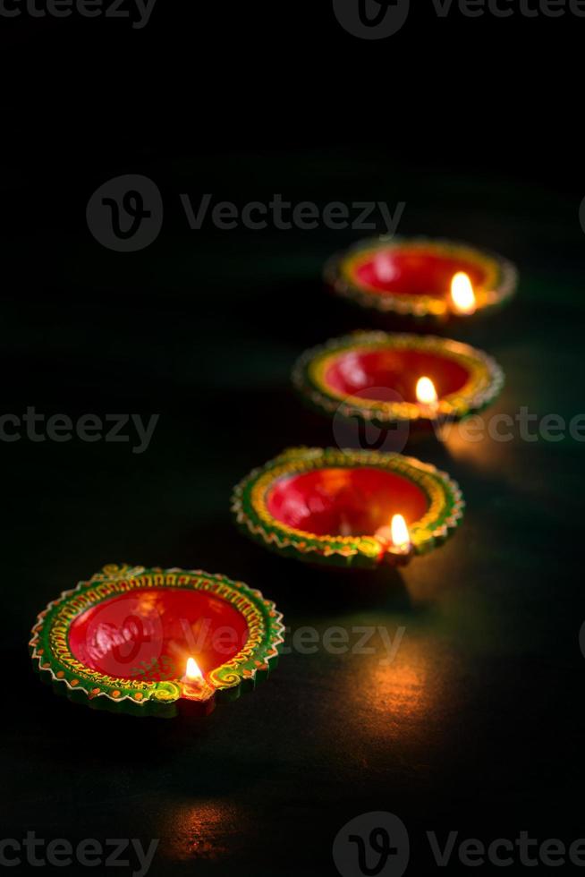 Happy Diwali - Clay Diya lamps lit during Diwali celebration. Greetings Card Design of Indian Hindu Light Festival called Diwali photo