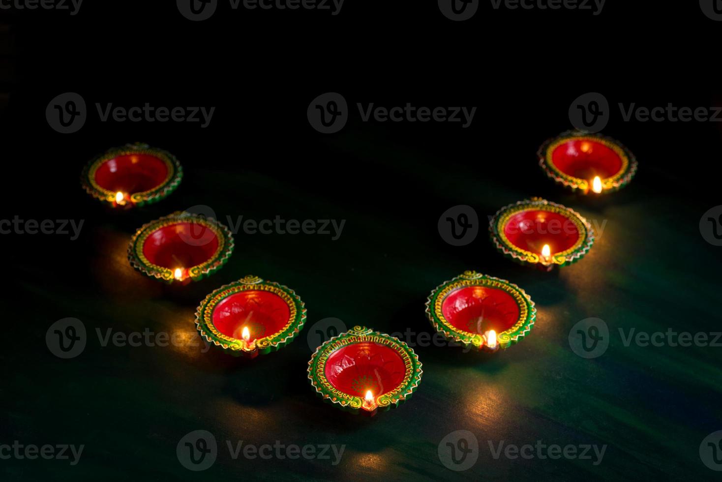 Happy Diwali - Clay Diya lamps lit during Diwali celebration. Greetings Card Design of Indian Hindu Light Festival called Diwali photo