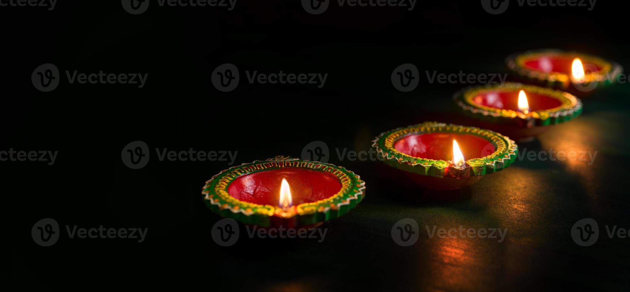 Happy Diwali - Clay Diya lamps lit during Diwali celebration. Greetings Card Design of Indian Hindu Light Festival called Diwali photo