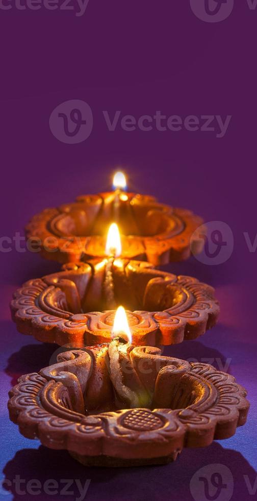 Clay diya lamps lit during Diwali Celebration. Greetings Card Design Indian Hindu Light Festival called Diwali photo