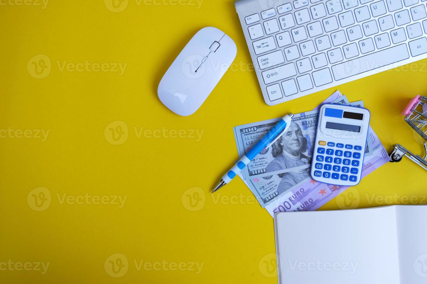 Top view on working space with office equipment and space for text,  concept of money on a yellow background represents finance and banking photo