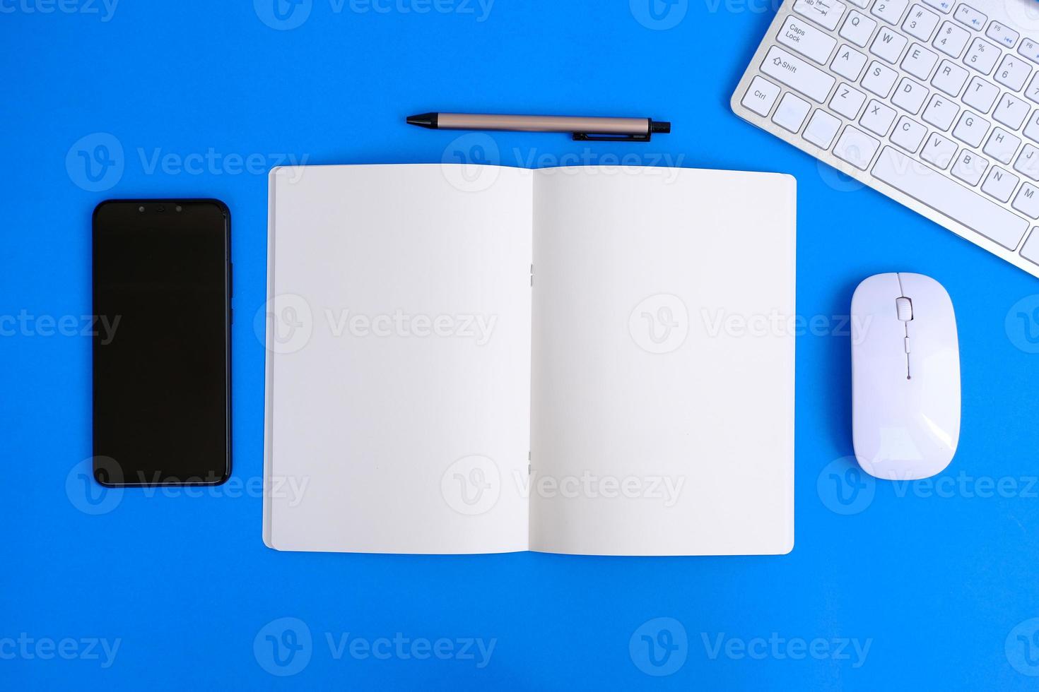 Notebook with pen are on top of office desk table with computer tools and supplies. Top view with copy space, flat lay.  Finance and banking advertising photo