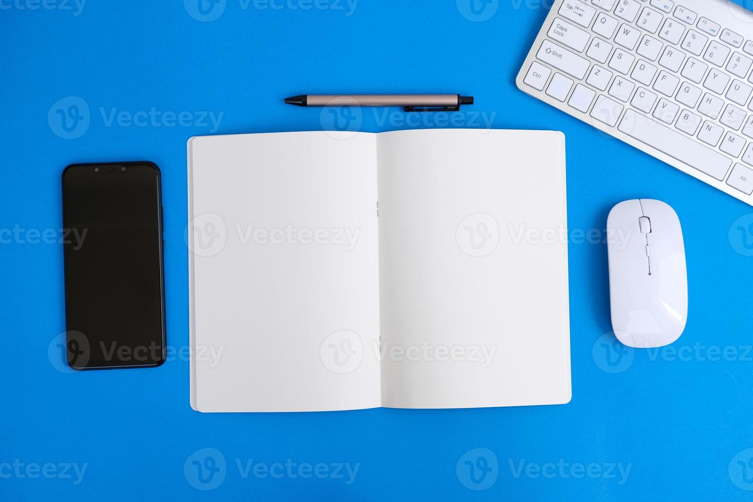 Notebook with pen are on top of office desk table with computer tools and supplies. Top view with copy space, flat lay.  Finance and banking advertising photo