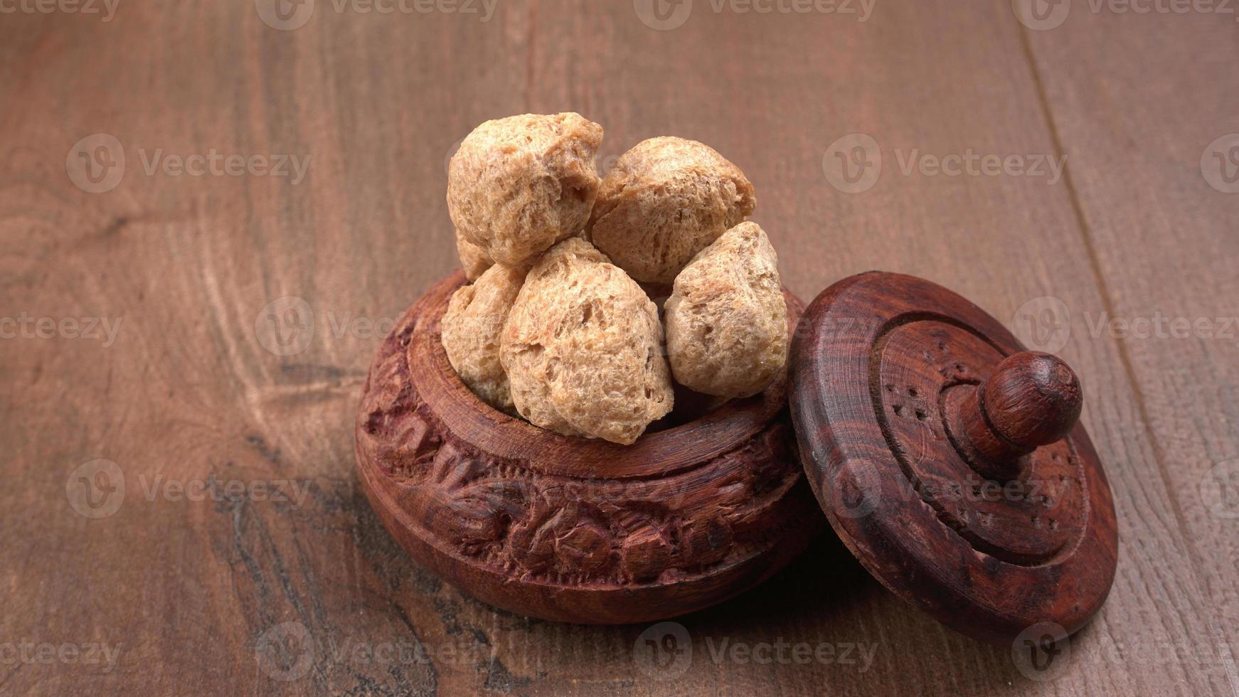 Raw soya chunks on dark background. Healthy, nutritious soybean meat, chunks isolated.Vegan food concept. photo