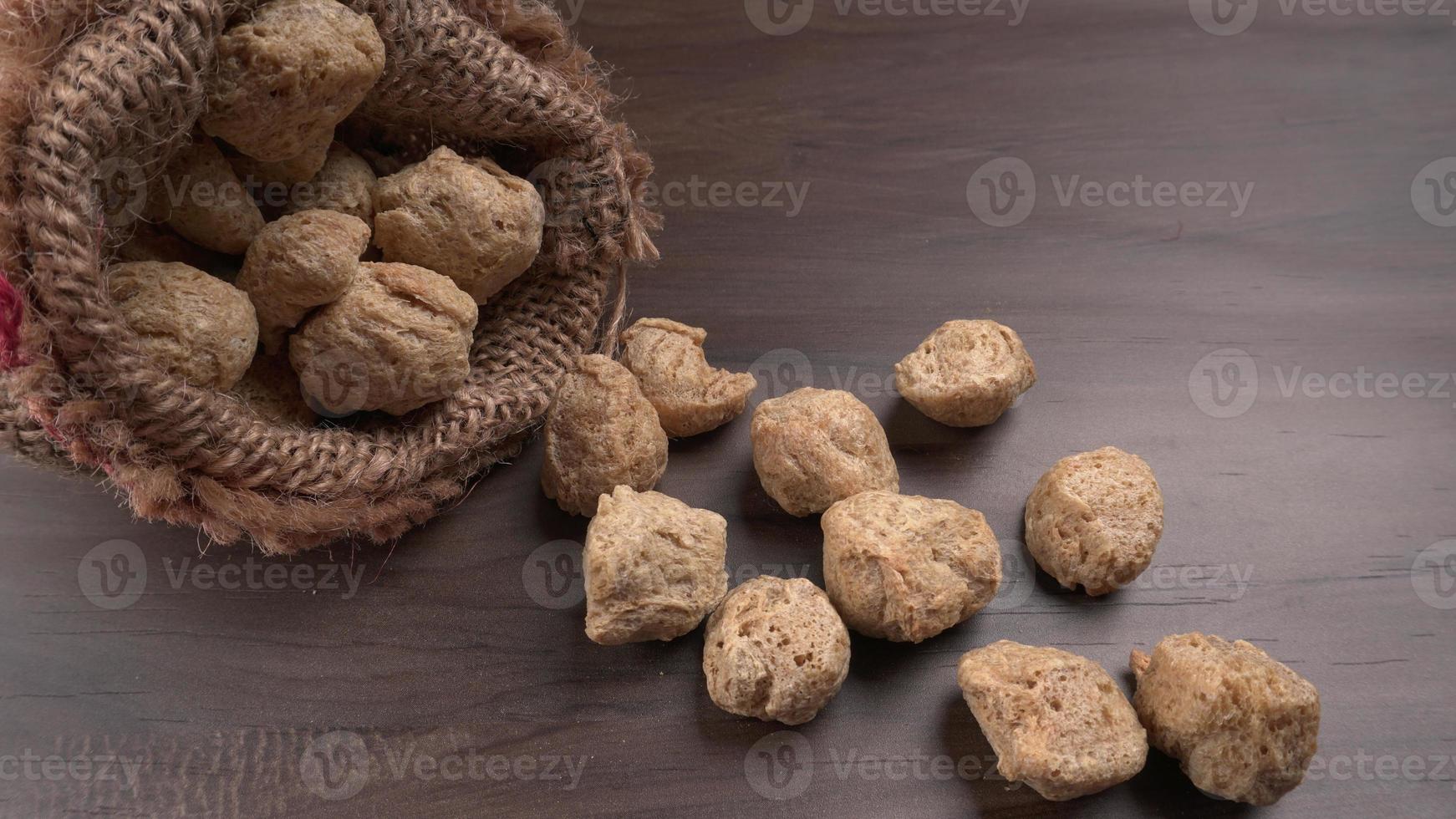 Raw soya chunks on dark background. Healthy, nutritious soybean meat, chunks isolated.Vegan food concept. photo