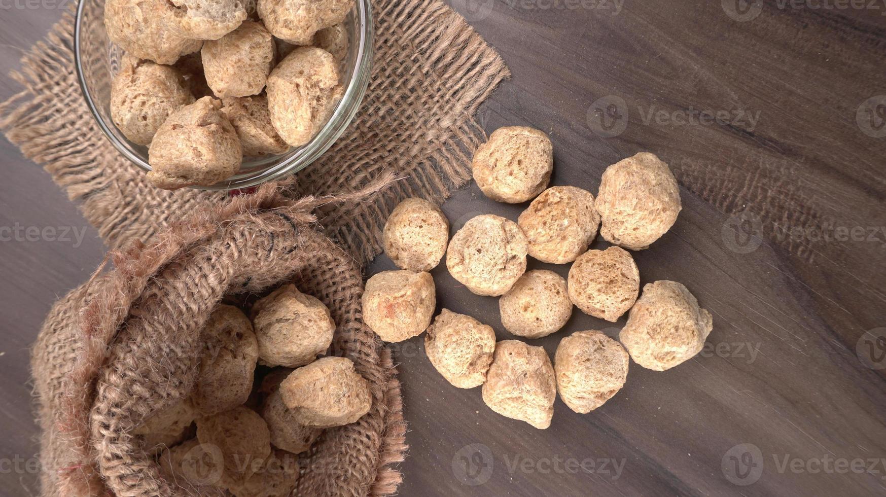 Raw soya chunks on dark background. Healthy, nutritious soybean meat, chunks isolated.Vegan food concept. photo