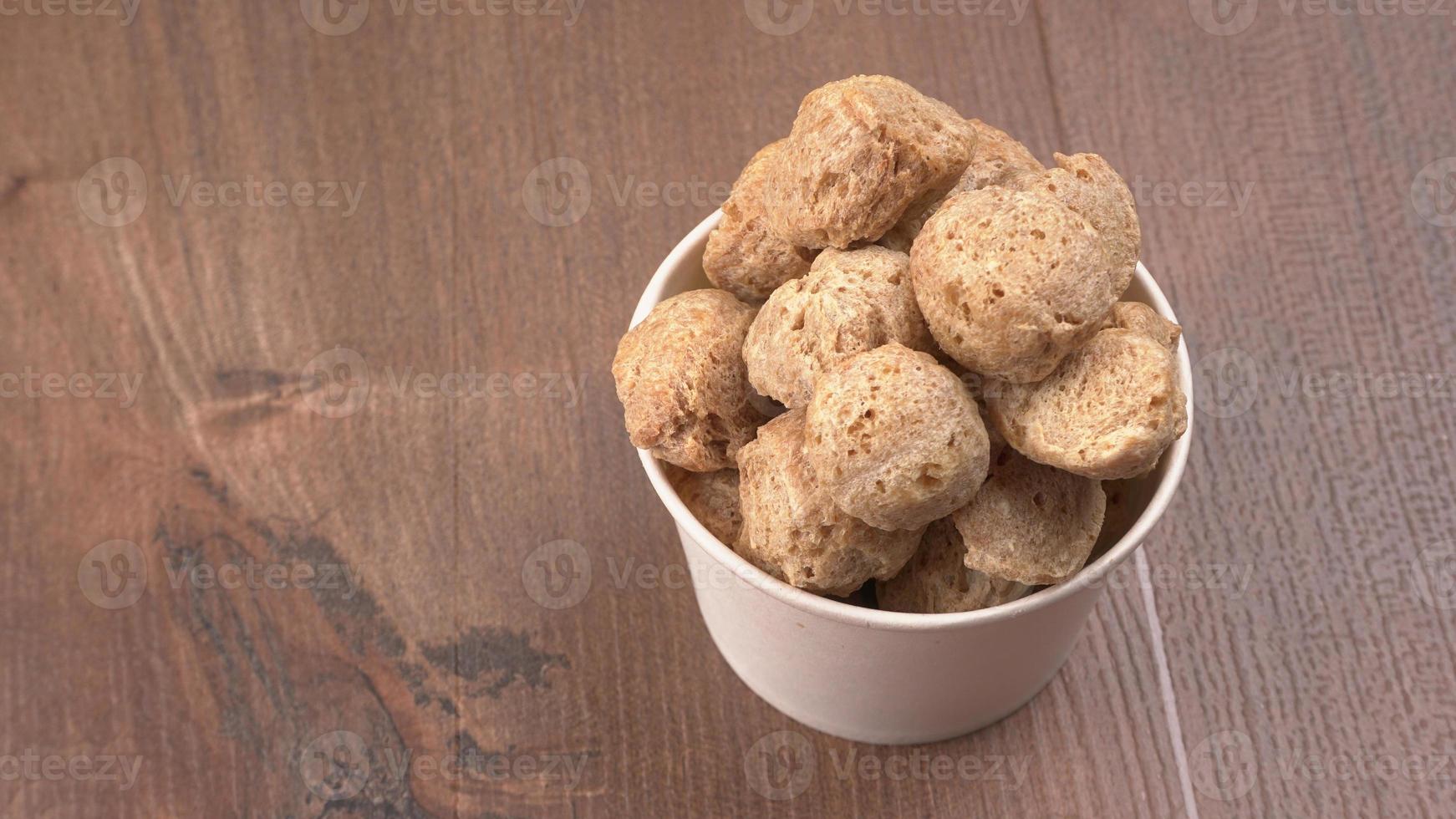 Raw soya chunks on dark background. Healthy, nutritious soybean meat, chunks isolated.Vegan food concept. photo