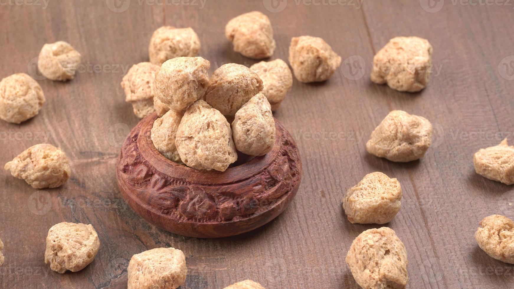 Raw soya chunks on dark background. Healthy, nutritious soybean meat, chunks isolated.Vegan food concept. photo