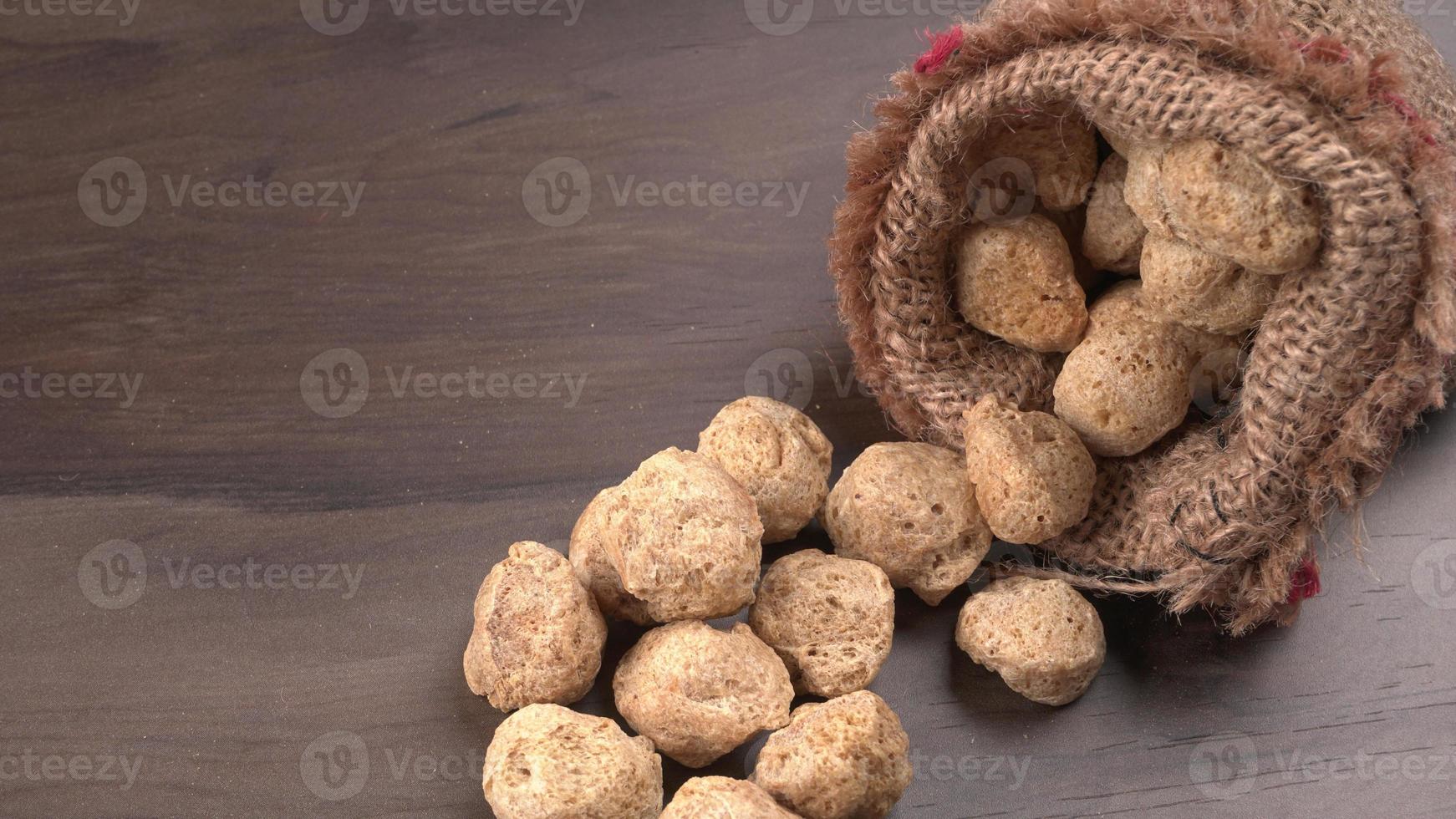 Raw soya chunks on dark background. Healthy, nutritious soybean meat, chunks isolated.Vegan food concept. photo