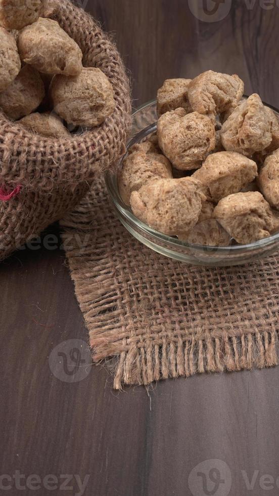 Raw soya chunks on dark background. Healthy, nutritious soybean meat, chunks isolated.Vegan food concept. photo