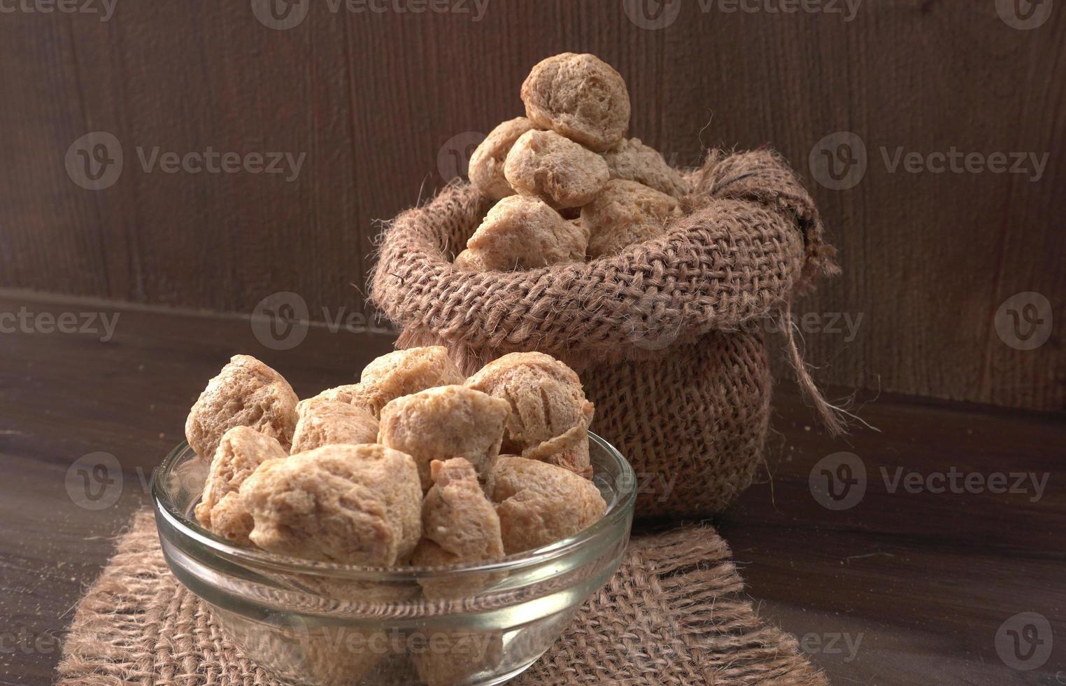 Raw soya chunks on dark background. Healthy, nutritious soybean meat, chunks isolated.Vegan food concept. photo