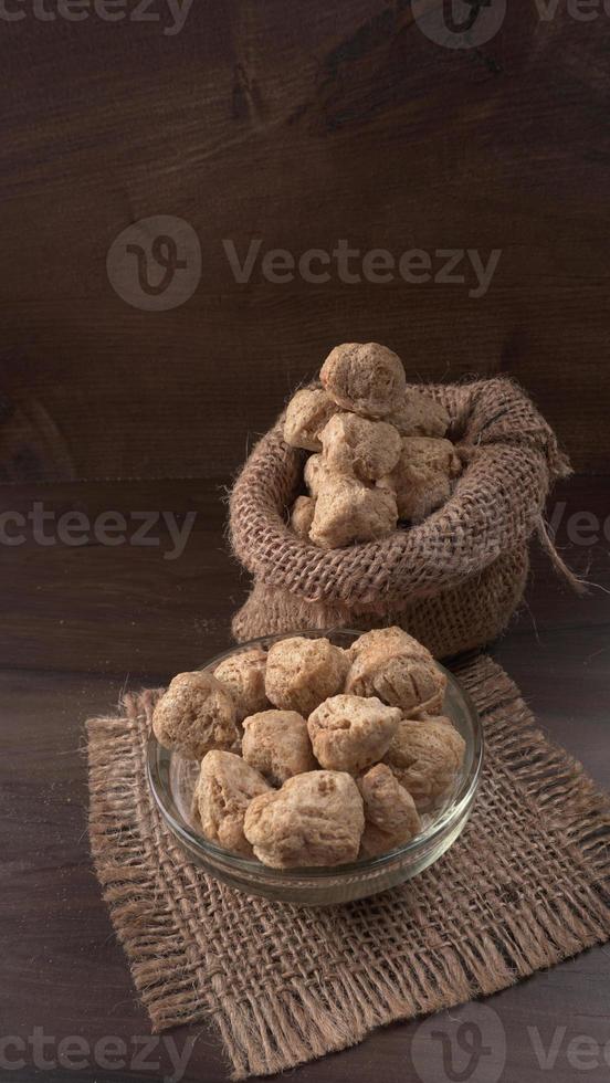 Raw soya chunks on dark background. Healthy, nutritious soybean meat, chunks isolated.Vegan food concept. photo