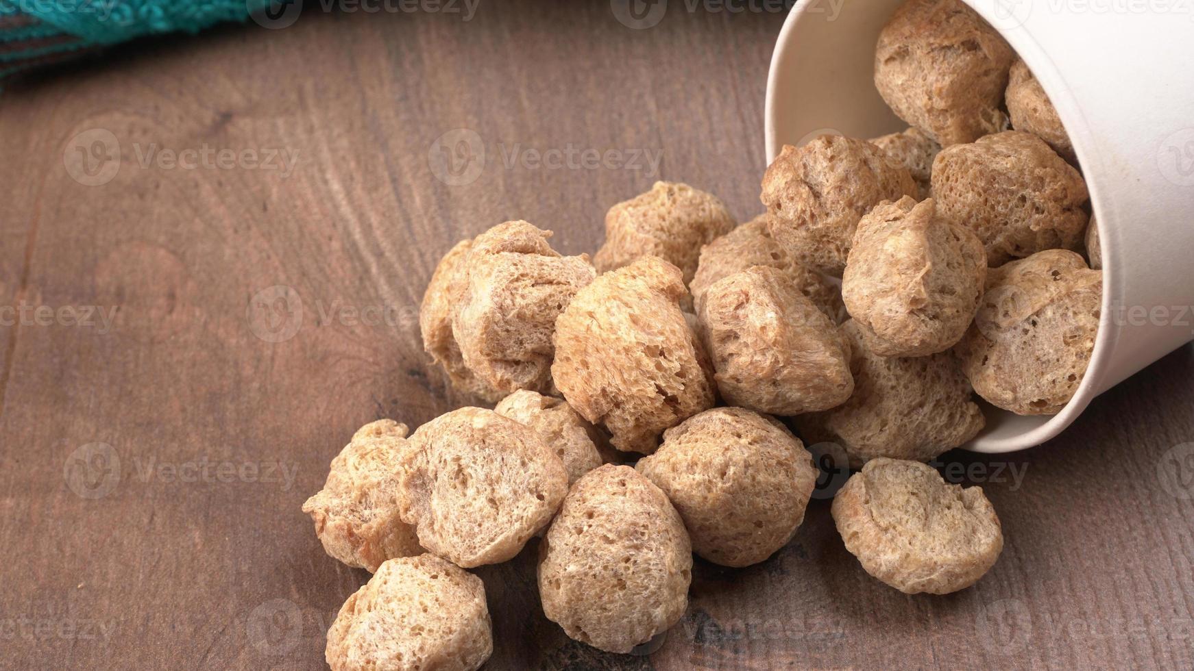 Raw soya chunks on dark background. Healthy, nutritious soybean meat, chunks isolated.Vegan food concept. photo