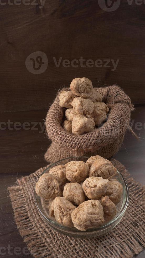 Raw soya chunks on dark background. Healthy, nutritious soybean meat, chunks isolated.Vegan food concept. photo