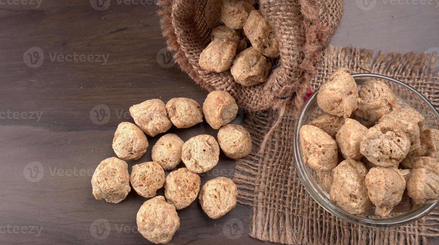 Raw soya chunks on dark background. Healthy, nutritious soybean meat, chunks isolated.Vegan food concept. photo