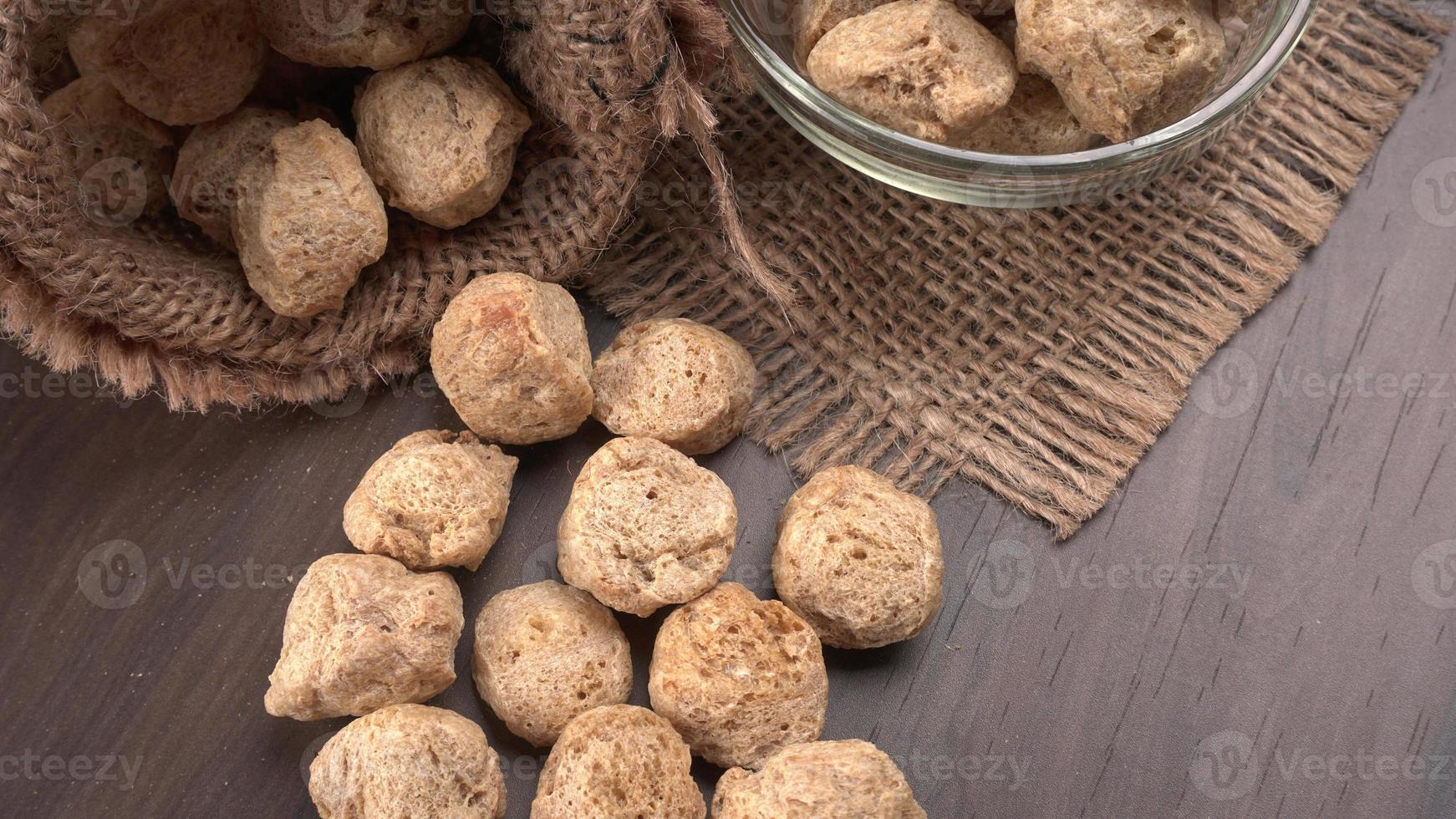 Raw soya chunks on dark background. Healthy, nutritious soybean meat, chunks isolated.Vegan food concept. photo