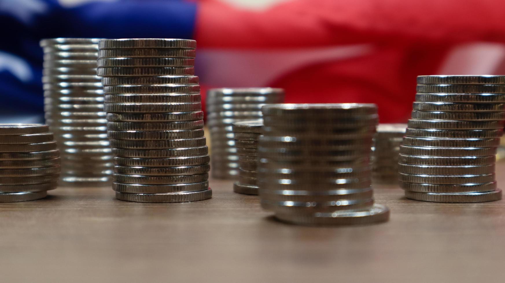 American coins with the flag of the United States of America. Investment concept, business finance and money saving. US coins stacked against the background of the American flag. Selective focus. photo