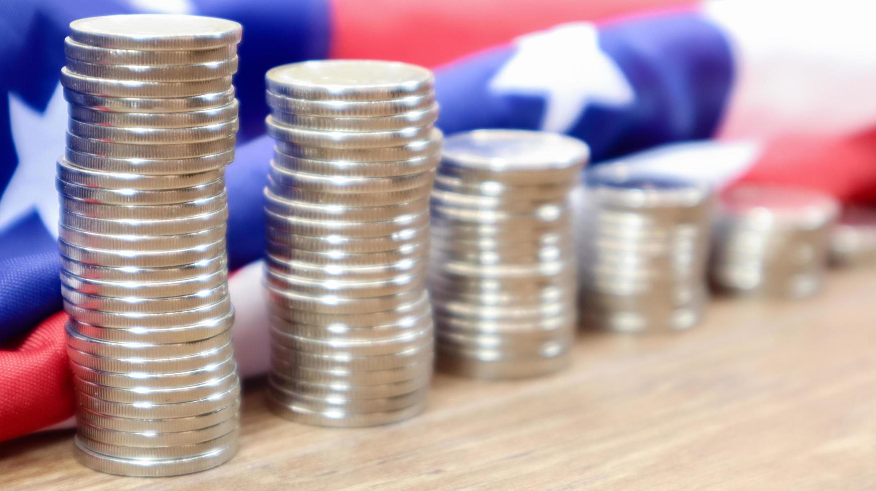 American coins with the flag of the United States of America. Investment concept, business finance and money saving. US coins stacked against the background of the American flag. Selective focus. photo