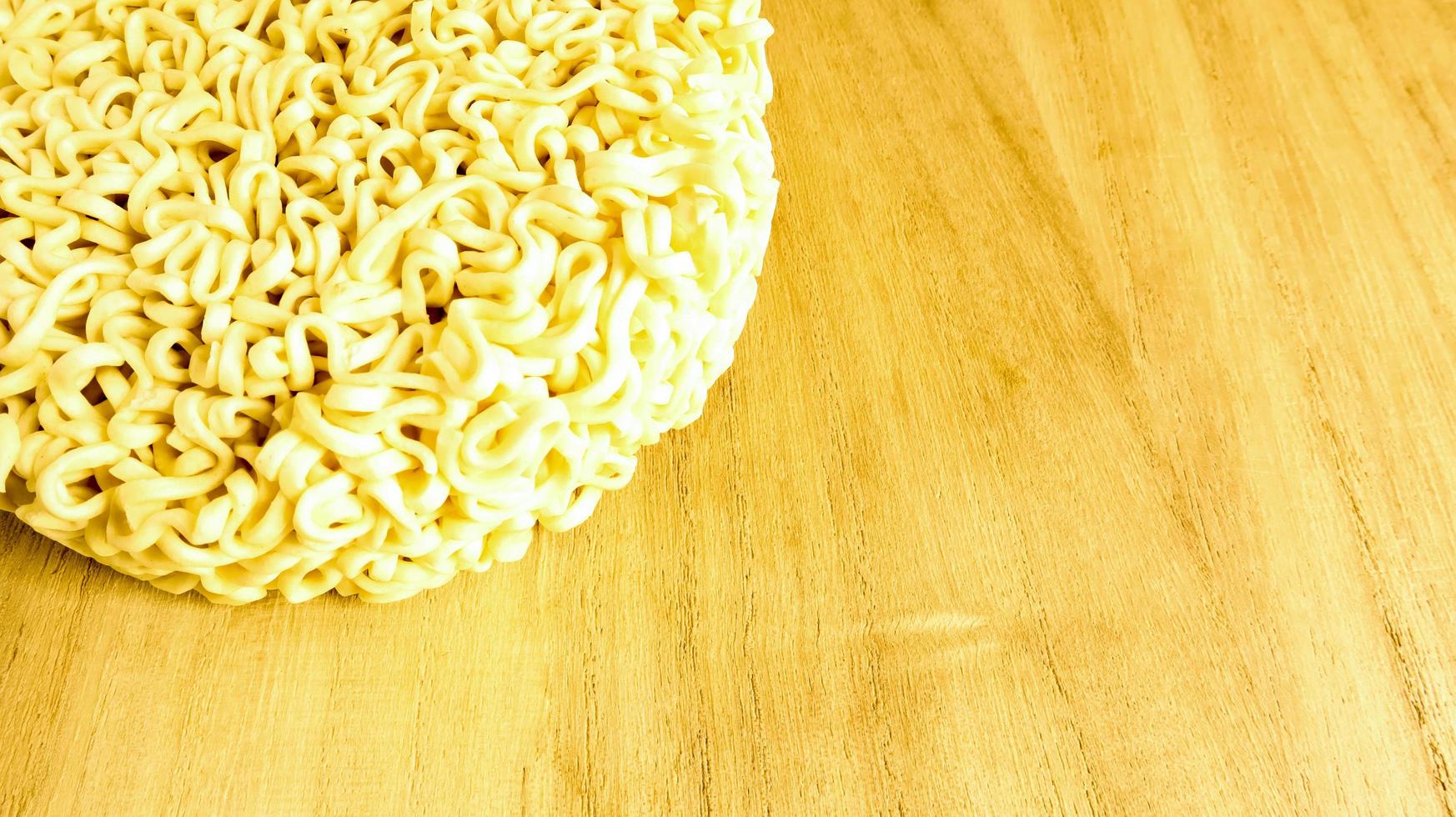 fideos instantáneos crudos en un plato de madera con espacio de copia para agregar texto en el fondo. pasta, para cuya preparación es suficiente verter agua hirviendo y esperar unos minutos. foto