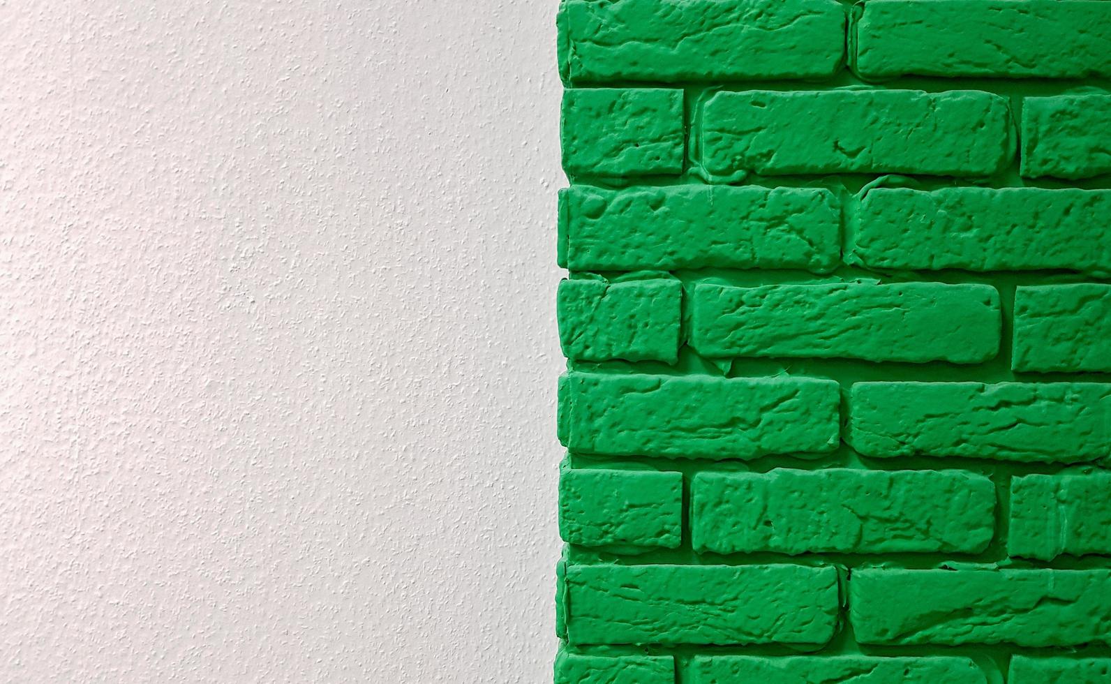 Modern new flat pink wall with a decorative brick column painted green. Abstract modern trendy texture background. Copy space empty space for your text and advertisement. photo