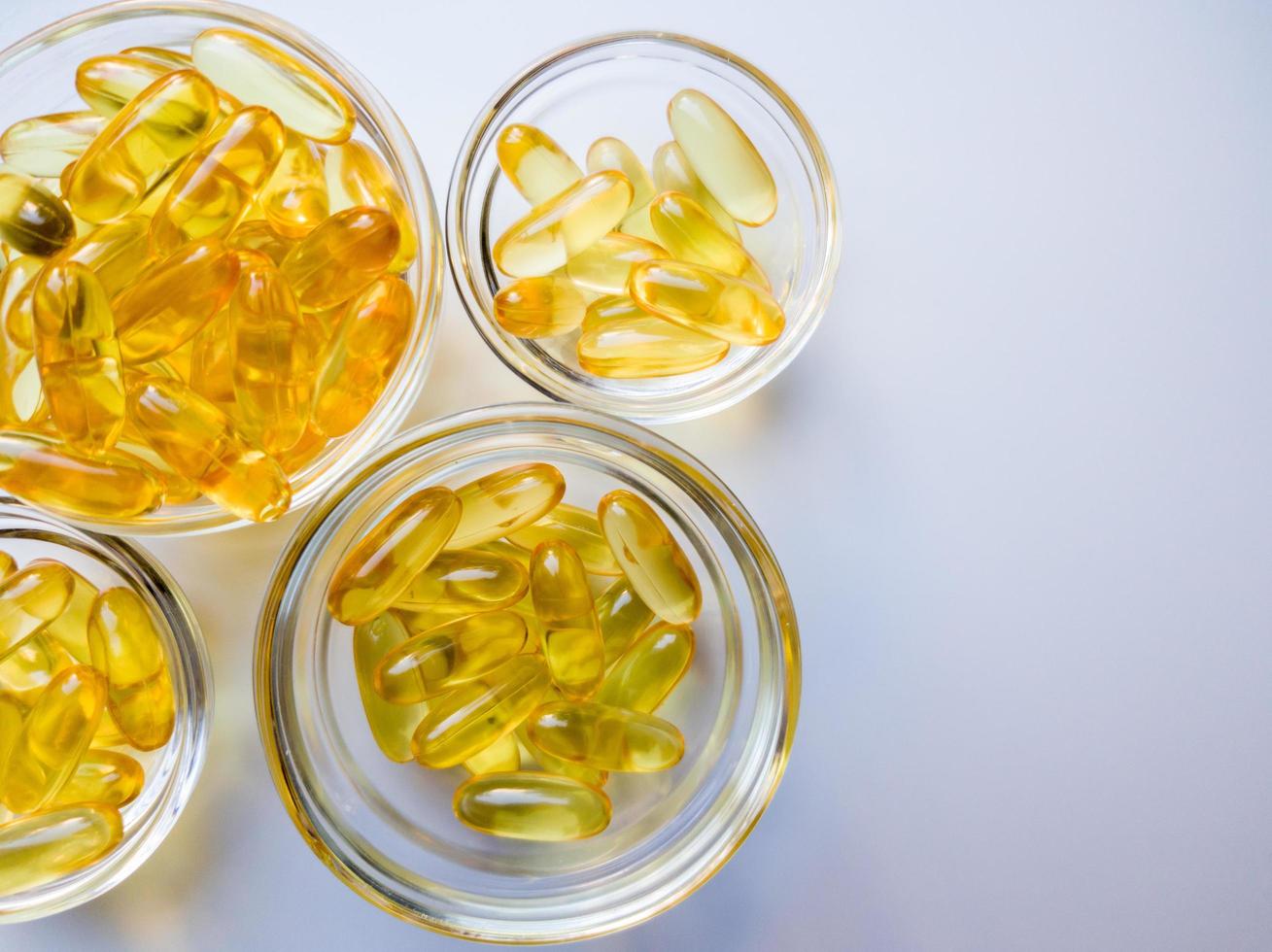 Fish oil capsules on a glass plate. A lot of vitamin omega 3 on a white background. Close-up, top view, high resolution product. Metabolism in the body. The body of calcium. A quick way to lose weight photo