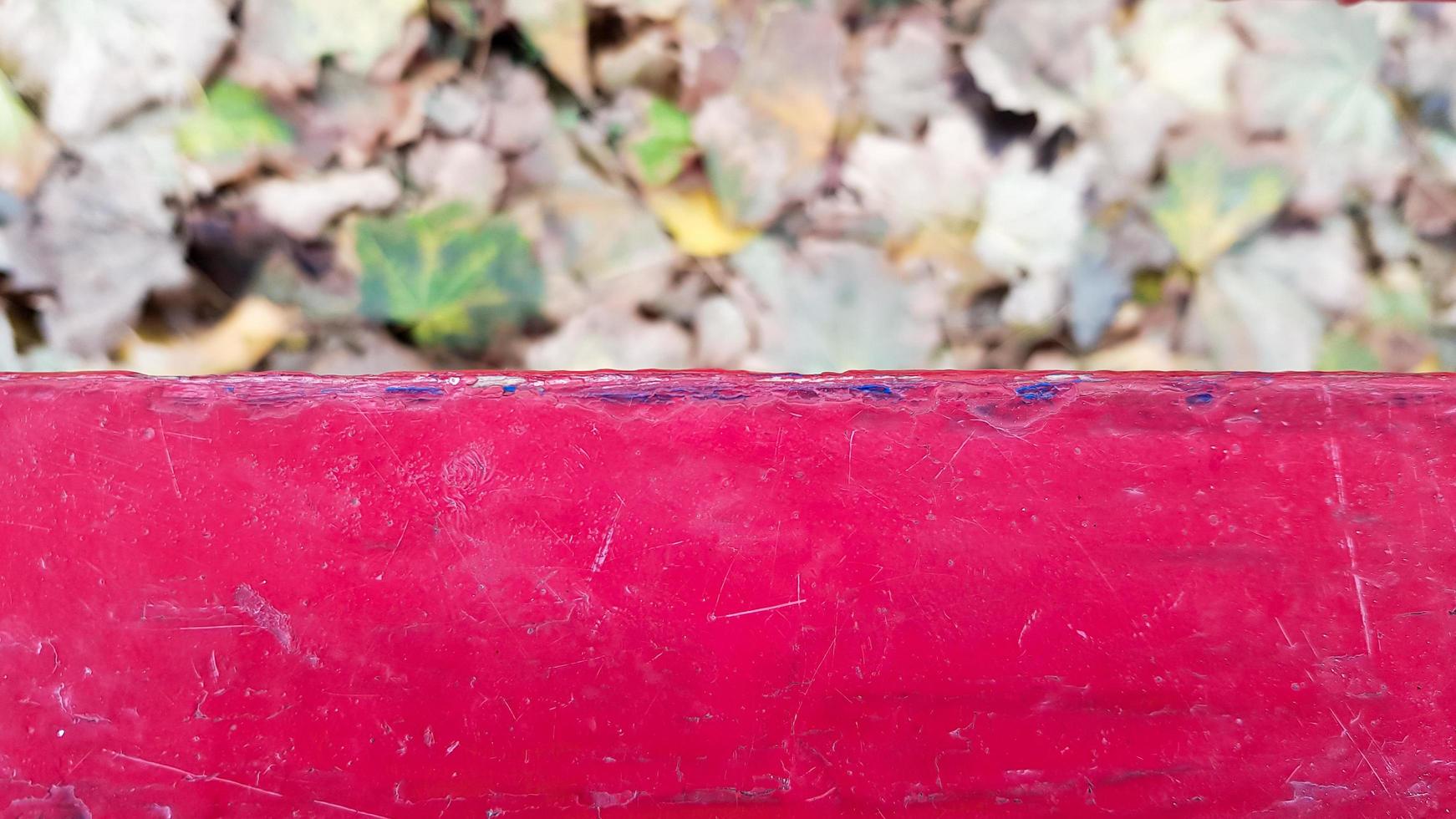 Red, green, yellow maple leaves. Indian summer. Falling leaves. Walk in the city park. Blurred focus. Park autumn concept, autumn background with copy space on red wooden background. photo