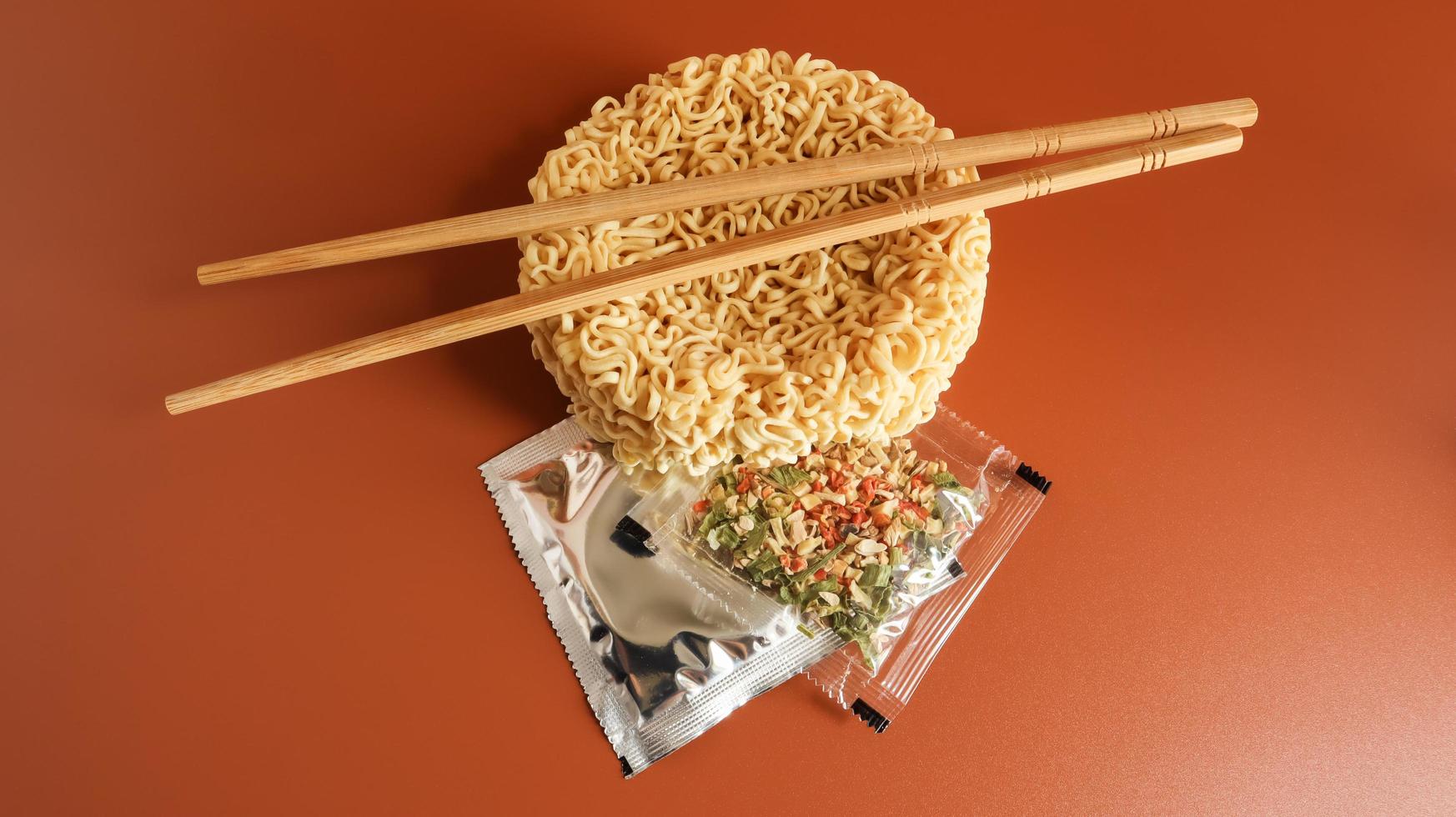 Raw instant noodles with chopsticks and spices. Copy space asian food. pasta, for the preparation of which it is enough to pour boiling water and wait a few minutes. flavored spaghetti. photo