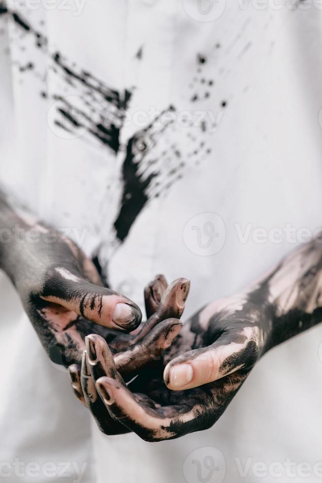 Dirty hands with black gold - oil. Pollution, eco, eco guilt, global warming, recycling concept photo