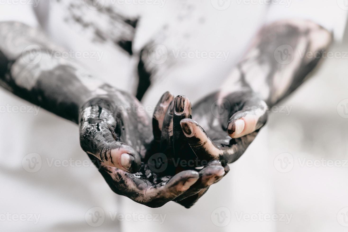 Dirty hands with black gold - oil. Pollution, eco, eco guilt, global warming, recycling concept photo