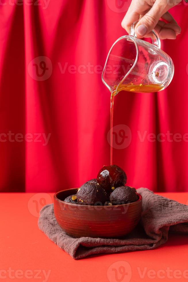 Sweet Gulab Jamun on red background photo