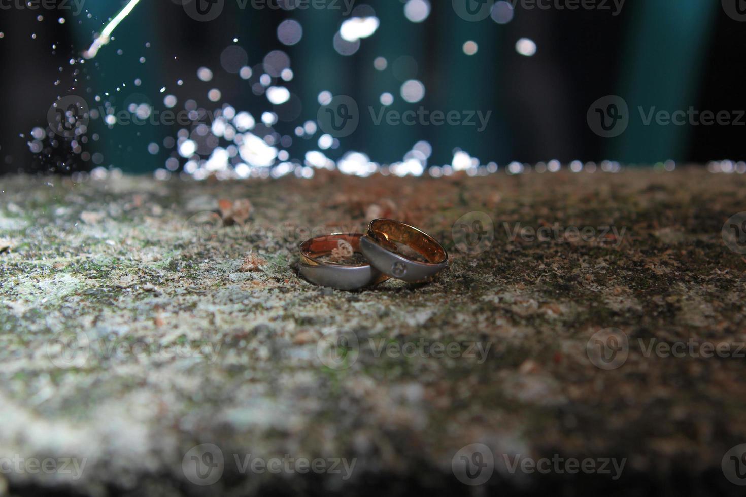 A pair of wedding rings on rock photo