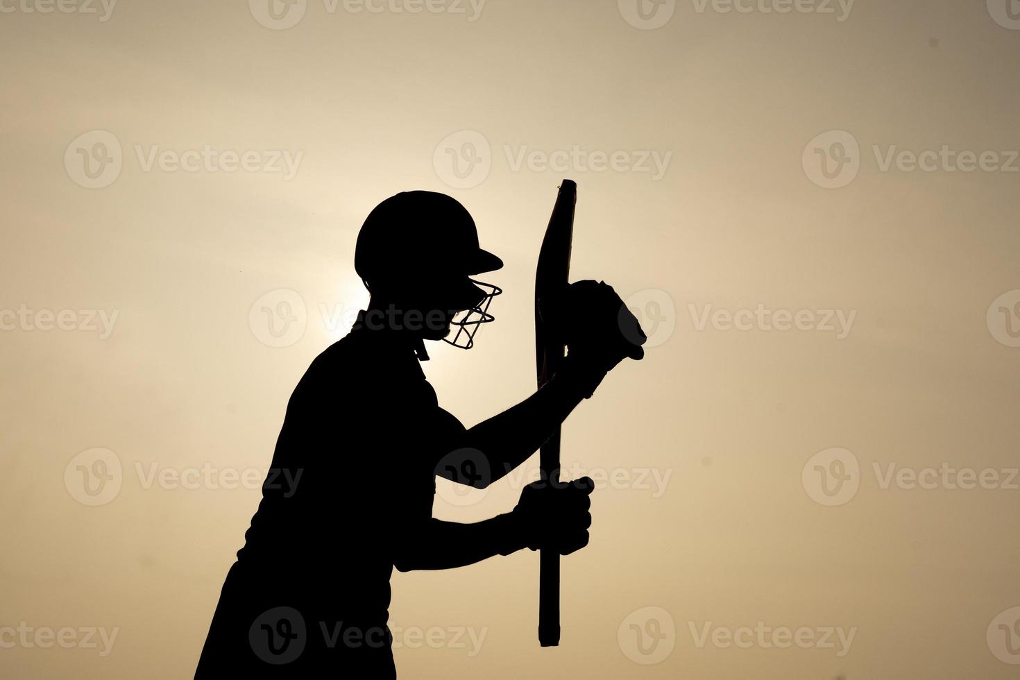 Silhouette of a cricketer celebrating after getting a century in the cricket match. Indian cricket players and sports concept. photo