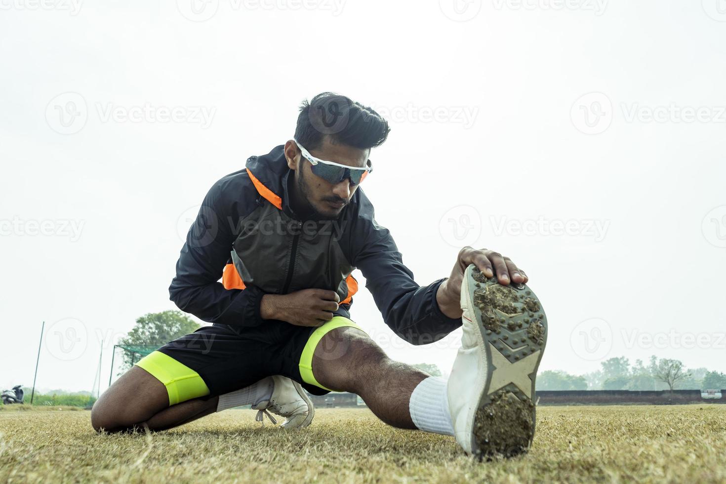 Young sportsman working out in the playground. player getting ready before a match and stretching his body. Sports and healthy lifestyle concept. photo