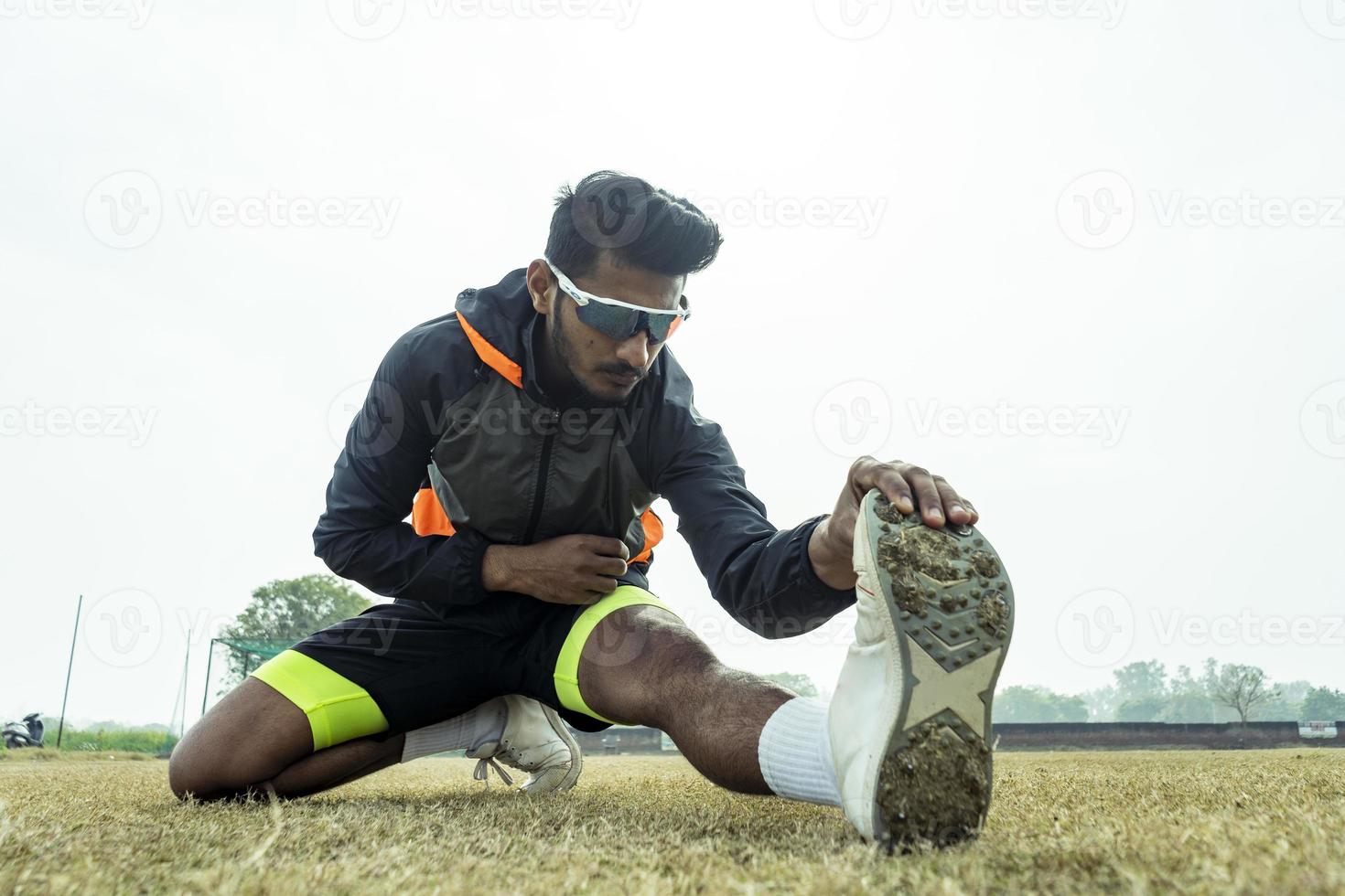 joven deportista trabajando en el patio de recreo. jugador preparándose antes de un partido y estirando su cuerpo. concepto de estilo de vida saludable y deportivo. foto