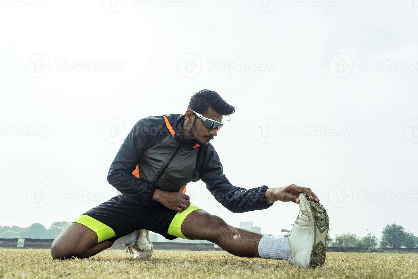 joven deportista trabajando en el patio de recreo. jugador preparándose antes de un partido y estirando su cuerpo. concepto de estilo de vida saludable y deportivo. foto