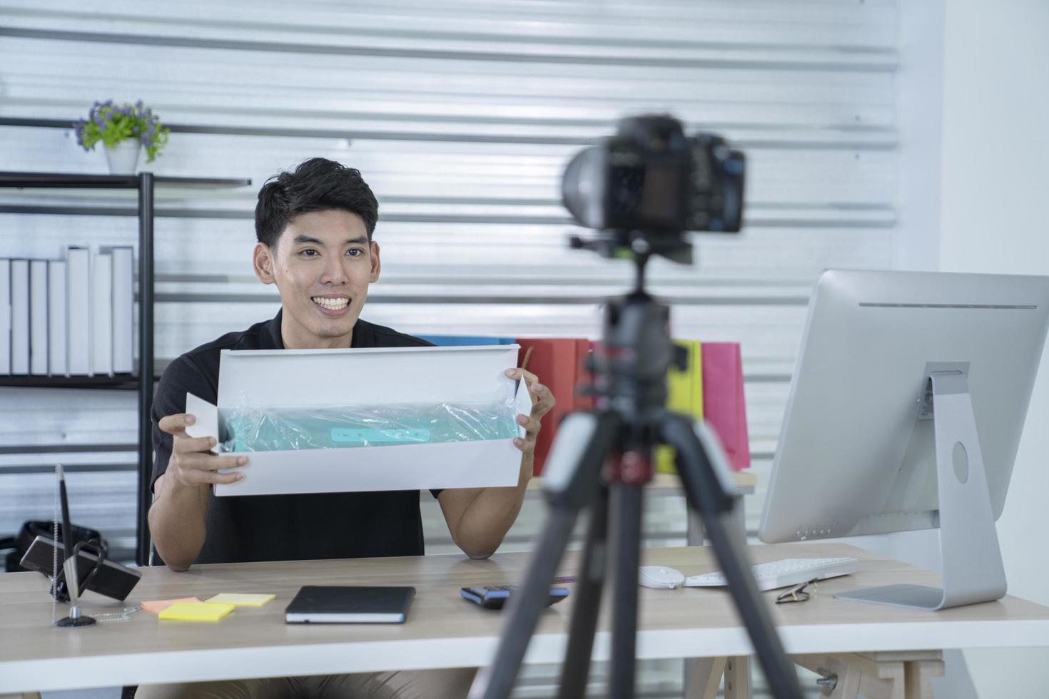 asian man blogger present and review product video broadcast live stream video to a social network. blogging, vlogging, online shopping, and social media concept photo