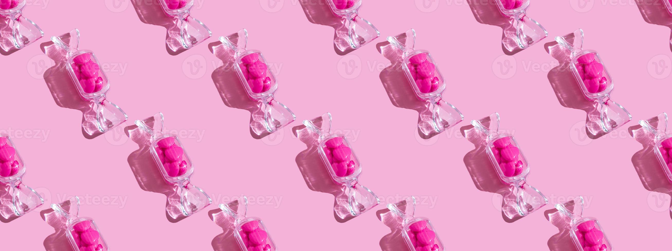 Transparent candy shaped box with sweet heart lollipops with hard shadow on pink background with copy space. The concept of Valentines day, mothers day. pattern photo