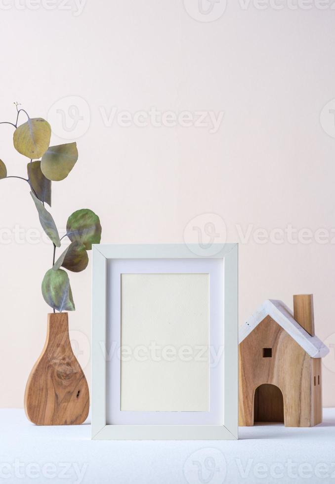 photo frame with eucalyptus branch in wood vase and wood toy on pastel background