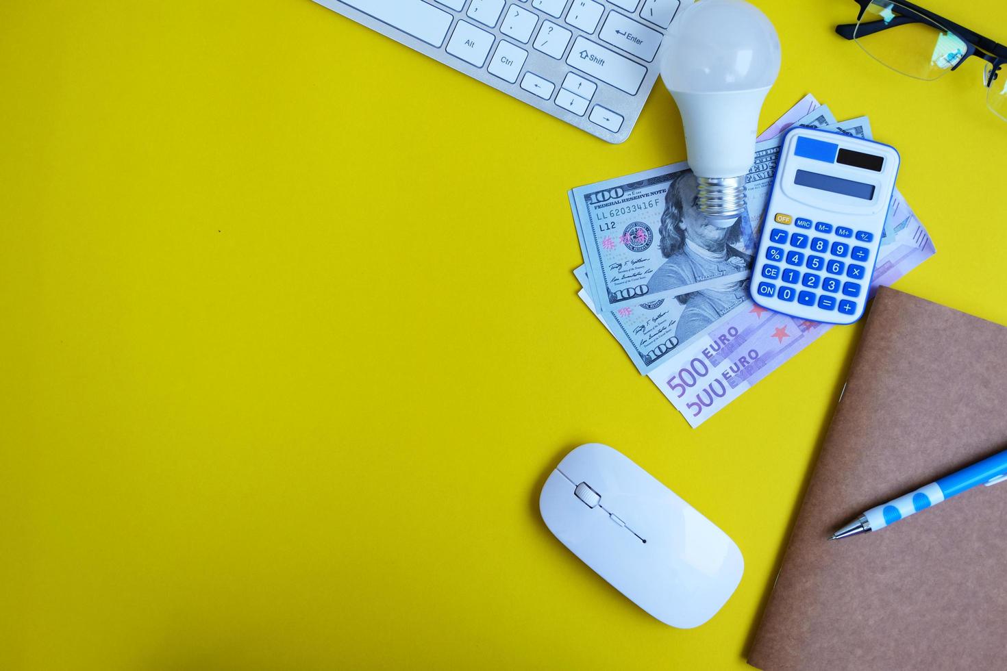 Top view on working space with office equipment and space for text,  concept of money on a yellow background represents finance and banking photo