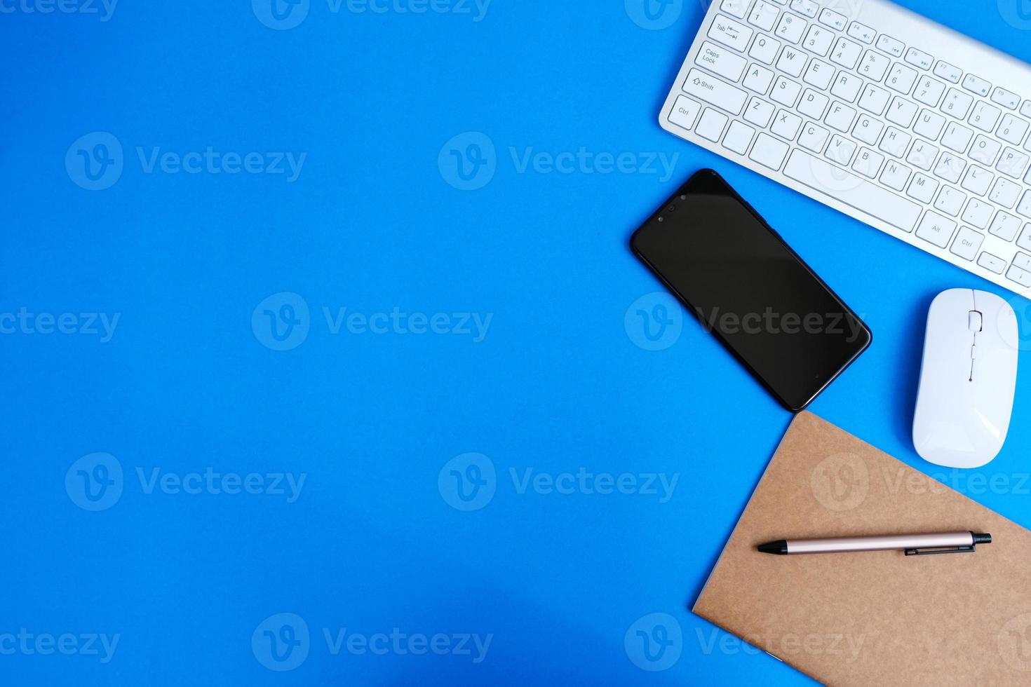 Notebook with pen are on top of office desk table with computer tools and supplies. Top view with copy space, flat lay.  Finance and banking advertising photo