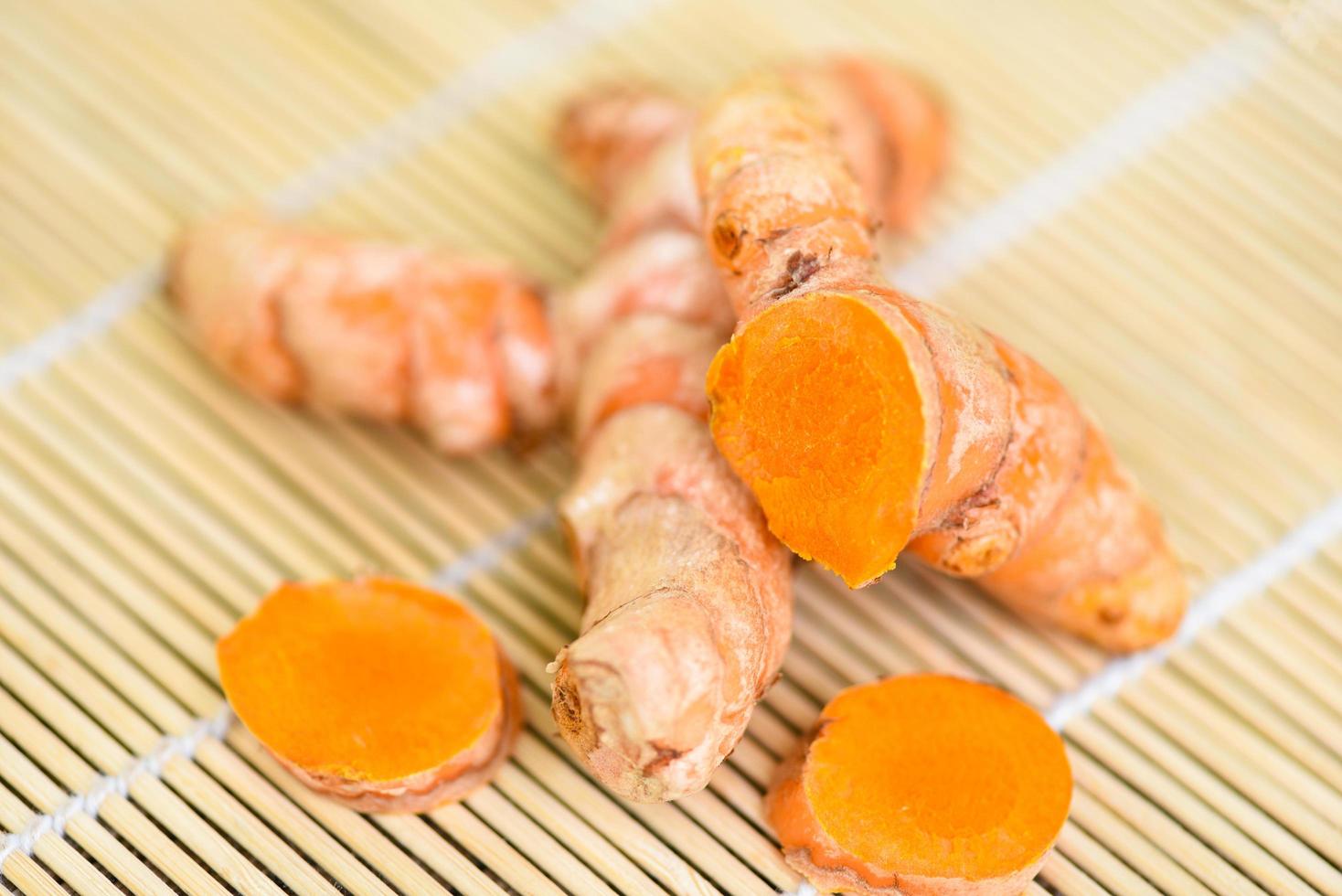 turmeric on wooden , fresh turmeric root for nature medicine herb and cooked ingredient food. photo