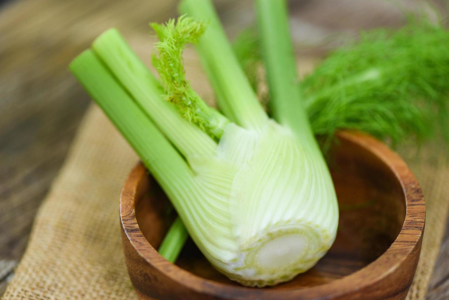 Hinojo vegetal del jardín, bulbos de hinojo crudo fresco listo para cocinar sobre fondo verde de madera de la naturaleza de los alimentos. foto