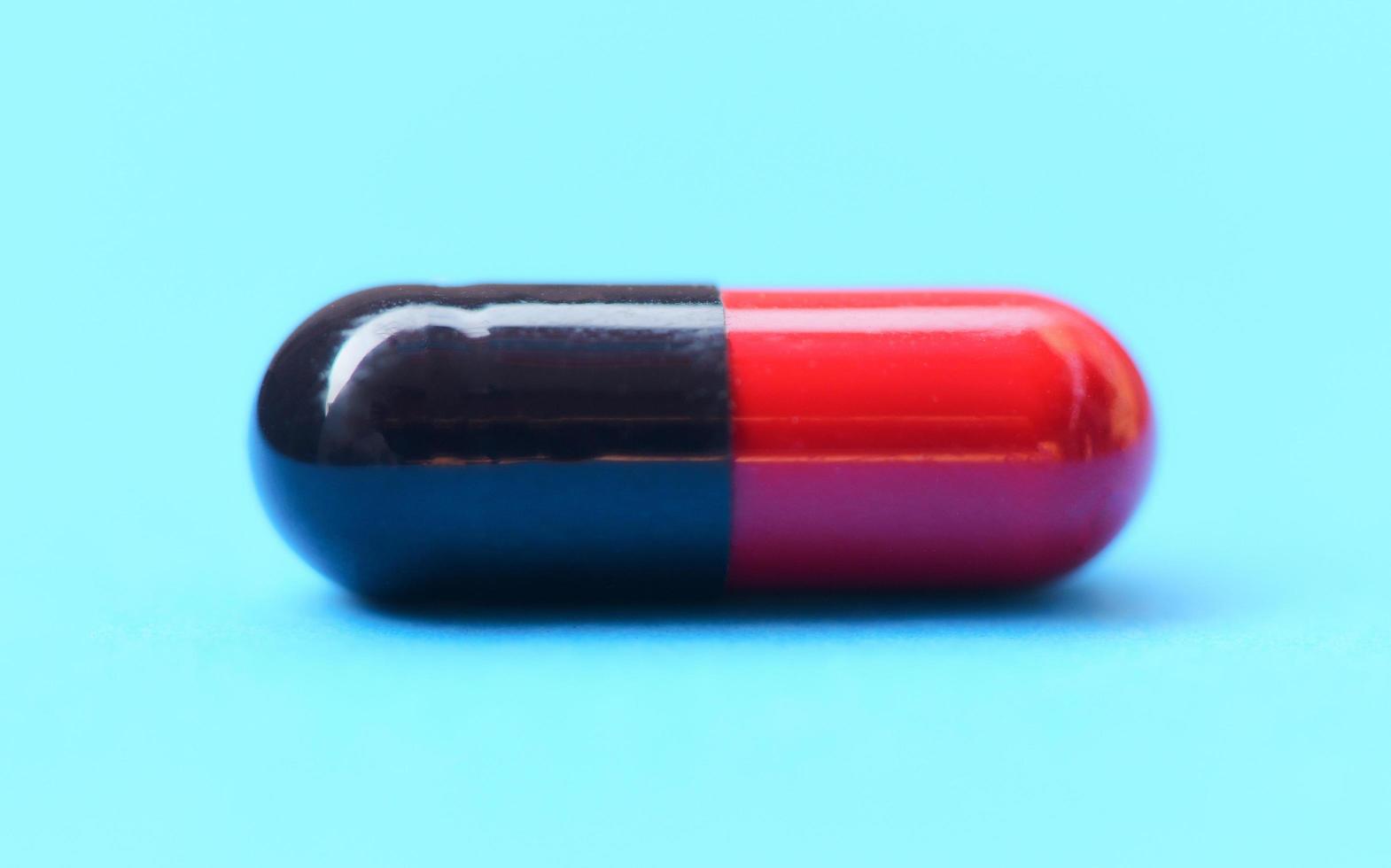 enfoque selectivo de la píldora de la cápsula: primer plano del concepto de medicamentos de la cápsula de las píldoras de medicina de color rojo y negro foto