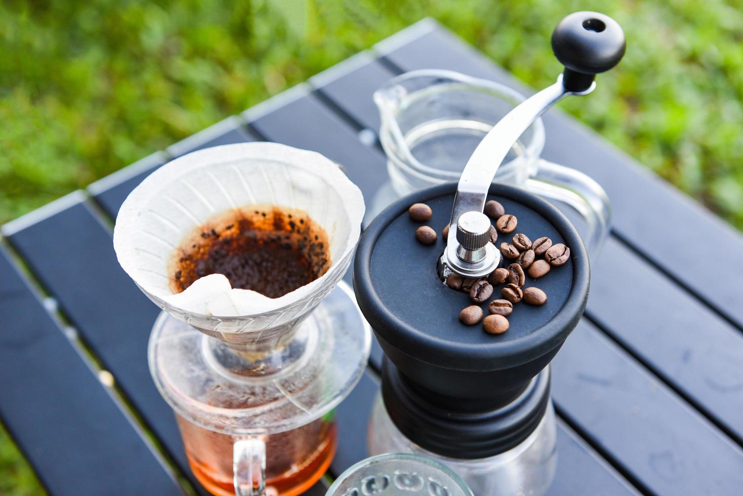 drip coffee barista pouring water on filtered brewing, make cup hand drip coffee in glass jar on outdoors. photo