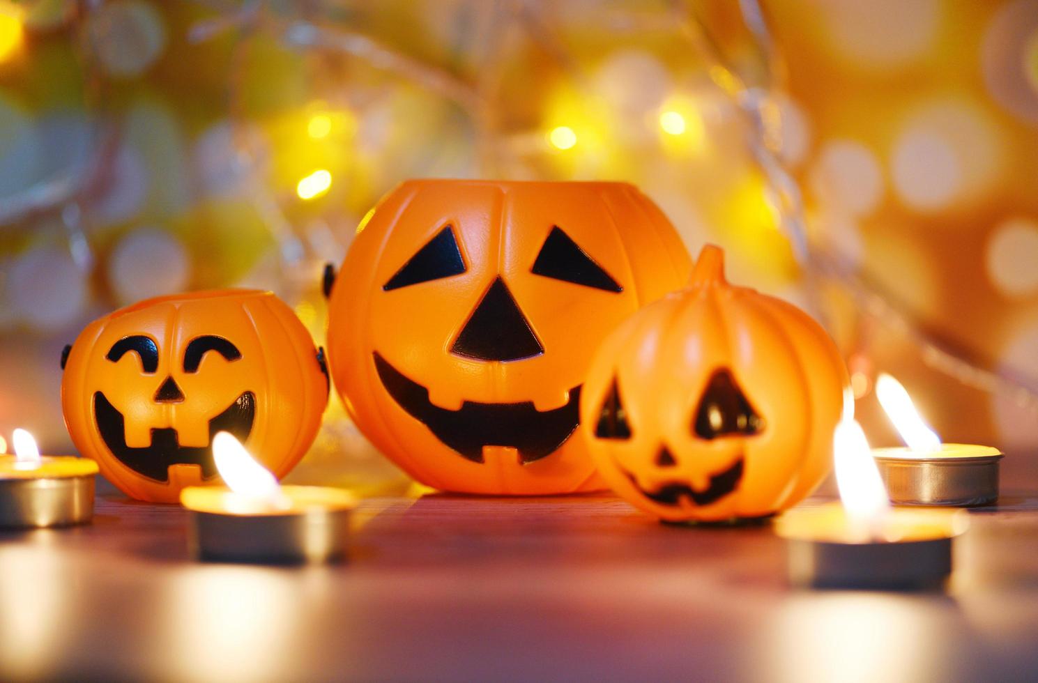 Halloween background candlelight orange decorated holidays festive concept - funny faces jack o lantern pumpkin halloween decorations for party accessories object with candle light bokeh photo